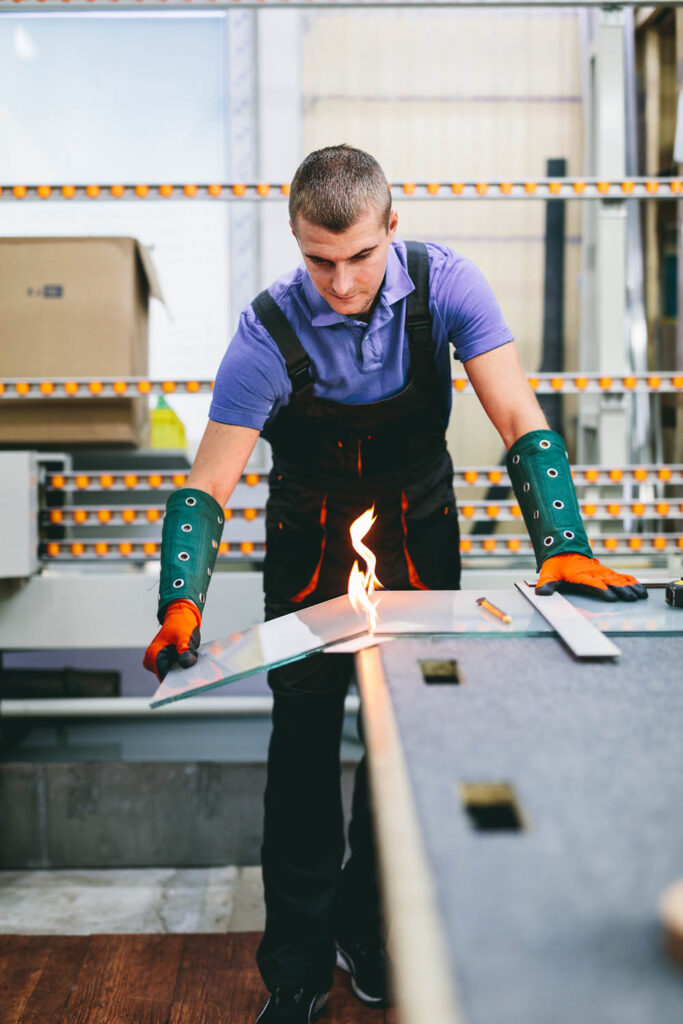 glazier-worker-cutting-glass-with-fire-in-a-worksh-8FD3ZUB.jpg