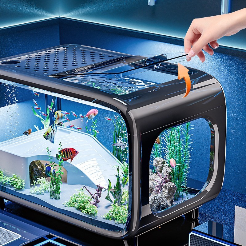 1e17c98a-7c09-480c-b5c3-6b3b9e0d6a7e-2jpg - Aquassi Ltd | Award-winning Aquarium Design & Aquascaping Sleek Desktop Aquarium with Colorful Fish and Aquatic Plants, Viewed from the Side As a Hand Adjusts the Top Lid Using Tongs and a Small Orange Arrow Indicates Opening.