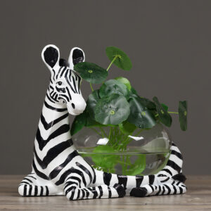 Zebra-patterned planter with a round glass bowl of water and green leafy plant inside.