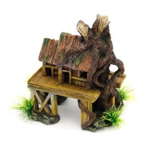 Miniature wooden hut on stilts entwined with a large, twisted tree root, set on a rocky base with small tufts of grass.