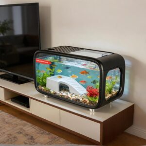 Small home aquarium on a TV stand with colorful fish and decorative plants, labeled 'Highest Water Level' on the tank.